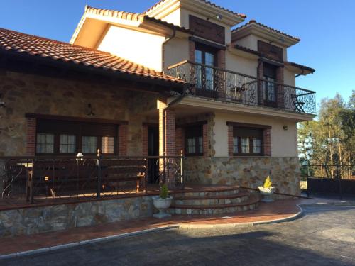 a large house with a balcony on the side of it at Apartamentos rurales la Aguilera in Oviñana