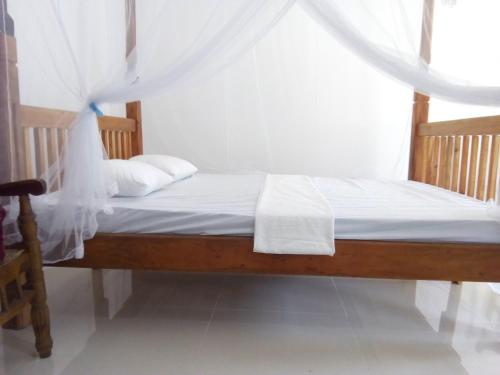 a bedroom with a bed with white sheets and a window at T & U Homestay in Katunayaka