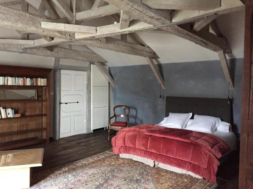 una camera da letto con un letto con una coperta rossa di La Jauberthie a Vanxains