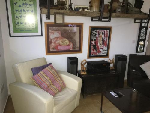 a living room with a white chair and a table at MP Cozy Apartment Near the Sea in Paphos City