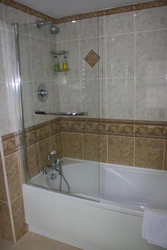 a bathroom with a bath tub with a shower at High Dalby House in Pickering