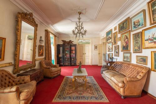 una sala de estar con sofás y pinturas en las paredes. en Casa dos Arcos - Charm Guesthouse, en Albufeira