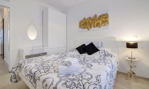 a white bedroom with a bed with a black and white comforter at Apartments Luka - Villa Sunce in Senj
