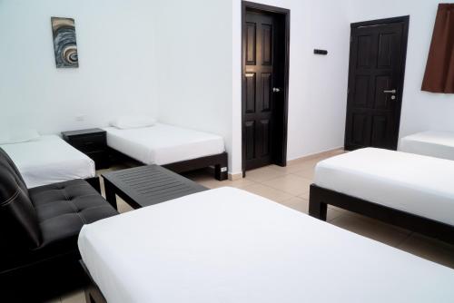 a room with three beds and a couch in it at We playa Hotel in Playa del Carmen