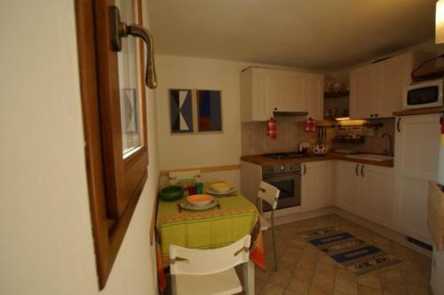 a small kitchen with a table and chairs in it at CASA VISTA LAGO E GIARDINO in Porlezza