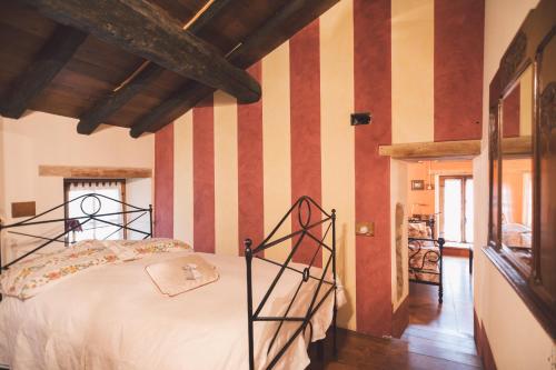 a bedroom with a bed with striped walls at Mulìn Turcìn in Coassolo Torinese