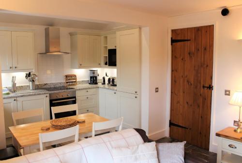 eine Küche und ein Esszimmer mit einem Tisch und einer Couch in der Unterkunft Dee Valley Cottages in Llangollen