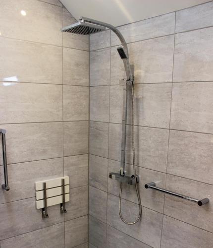 a shower with a shower head in a bathroom at Dee Valley Cottages in Llangollen
