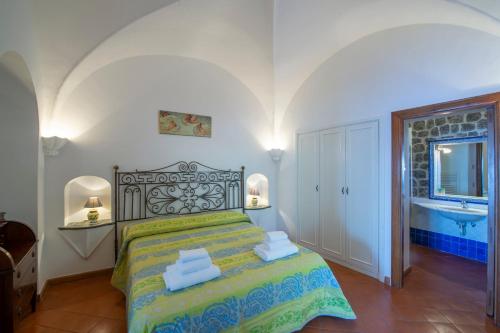 a bedroom with a bed and a bathroom with a sink at Villamena in Furore