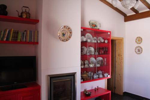 a living room with a tv and a red book shelf at Casa da Urra in Urra