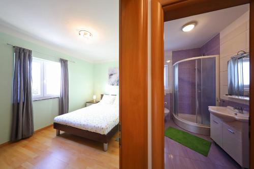 a bedroom with a bed and a sink and a mirror at Luxury Villa Nada with Pool in Petrcane