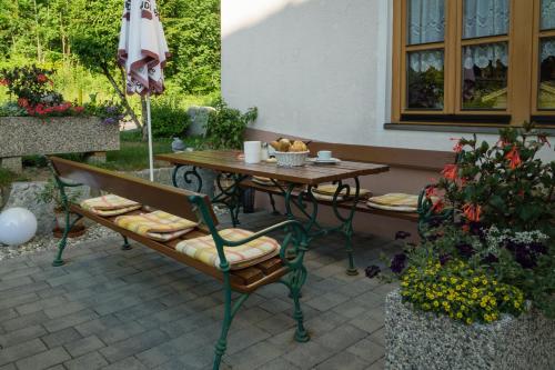 a table and chairs and an umbrella on a patio at Ferienwohnungen Mitterer in Weissensee