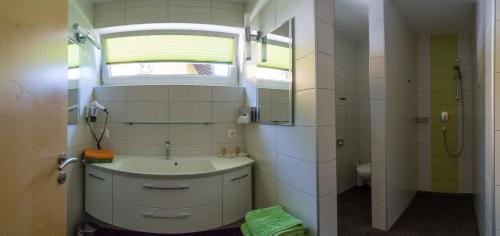 a bathroom with a sink and a toilet and a window at Ferienwohnungen Mitterer in Weissensee