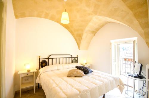 a bedroom with a bed in a room with an arched ceiling at Casa Del Sole in Matera