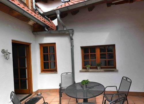 eine Terrasse mit einem Tisch und Stühlen vor einem Haus in der Unterkunft Ferienwohnung Bildgasse in Neustadt an der Weinstraße