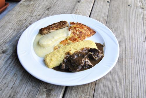 a white plate of food with bread and butter at Albergo Nuoitas in Forni di Sopra