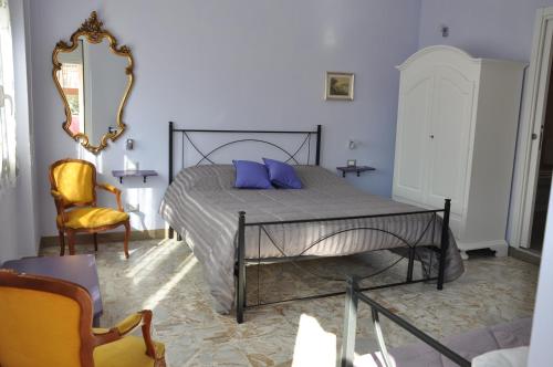 - une chambre avec un lit doté d'oreillers bleus et d'un miroir dans l'établissement B&B Mila e Nan, à Borghetto Santo Spirito