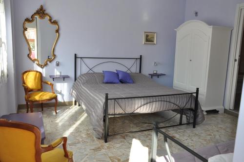 a bedroom with a bed with blue pillows and a mirror at B&B Mila e Nan in Borghetto Santo Spirito