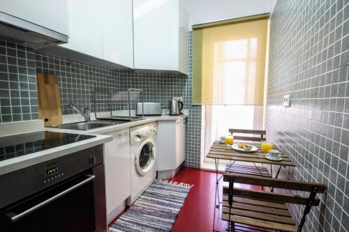 a kitchen with a washing machine and a sink at Belém Calling Apartment in Lisbon