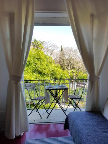 a bedroom with a bed and a balcony with a table and chairs at Belém Calling Apartment in Lisbon