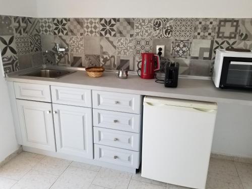 a kitchen counter with a sink and a microwave at Arillas Dream Studios in Arillas