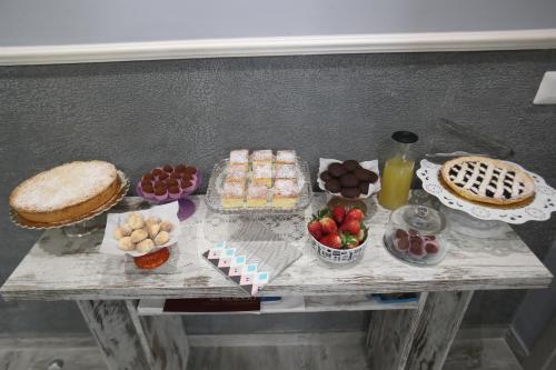 a table with desserts and other foods on it at La casa di Luce in Reggio Calabria
