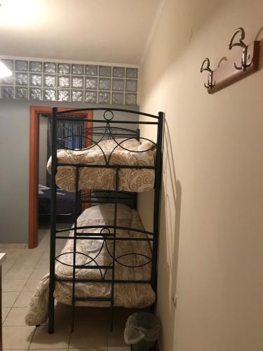 a iron bunk bed in a room with a staircase at Pinpoint Rooms in Mesolongion