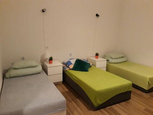 three beds in a room with green sheets at Stacja Centrum in Częstochowa