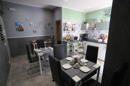 a dining room with a table and chairs and a kitchen at La casa di Luce in Reggio Calabria