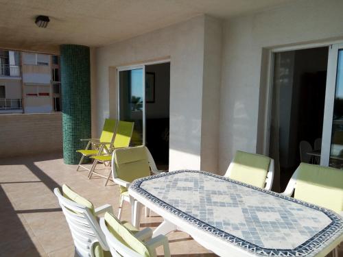 um pátio com uma mesa e cadeiras numa varanda em Gavina Azul em Villajoyosa