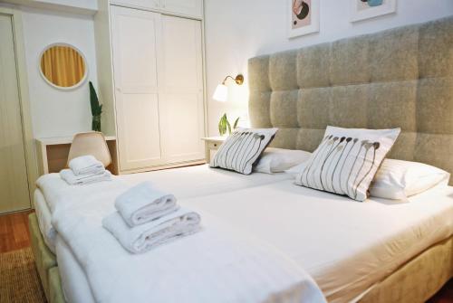 a bedroom with a large white bed with towels on it at Hotel Delfin in Zadar