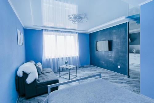 Dieses blaue Zimmer verfügt über ein Bett und einen TV. in der Unterkunft Сучасна 1-кімнатна квартира in Winnyzja