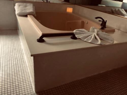 a bath tub with a sink with a towel at Postmarc Hotel and Spa Suites in South Lake Tahoe