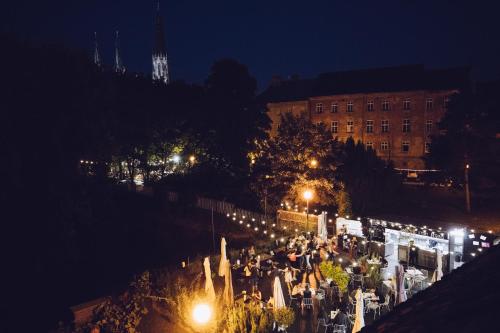 una multitud de personas caminando por una calle por la noche en Long Story Short Hostel & Café, en Olomouc