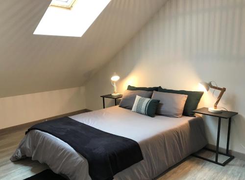 a bedroom with a bed with two lamps and a skylight at Appart T4 Christina contemporain, Vue Lac, climatisé avec parking in Aix-les-Bains