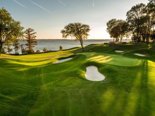 a view of a golf course with the ocean in the background at Kingsmill Resort in Williamsburg