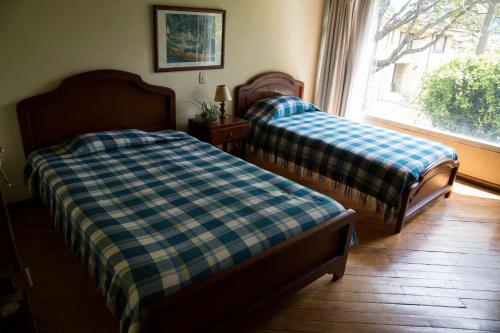 two beds sitting in a room with a window at Hostal Bogotá Real in Bogotá