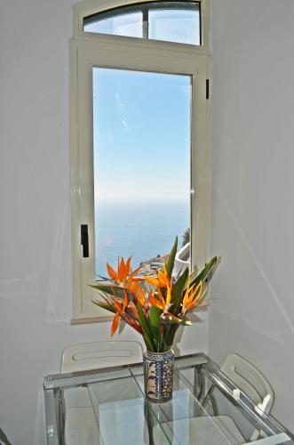 a vase on a glass table in front of a window at Palazzo Mansi in Ravello