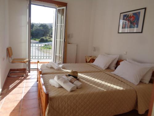 two beds in a room with a window at Melissani House in Karavomylos
