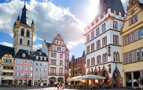 a group of buildings in a city with a clock tower at Holiday Home Wonderland with private Spa/Wellness in Ralingen