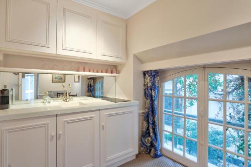 a kitchen with white cabinets and a large window at Pick A Flat's Apartments in Saint Germain - Paul-Louis Courier in Paris