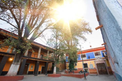 a building with the sun shining through the trees at Sanbernabé tres in Guanajuato