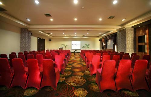 a conference room with red chairs and a screen at Aston Pontianak Hotel and Convention Center in Pontianak