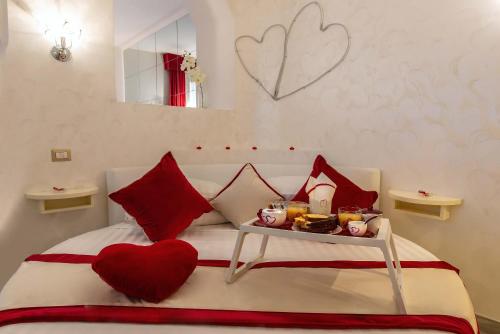 Schlafzimmer mit einem Bett mit einem roten herzförmigen Kissen in der Unterkunft Ripetta Luxury Del Corso in Rom