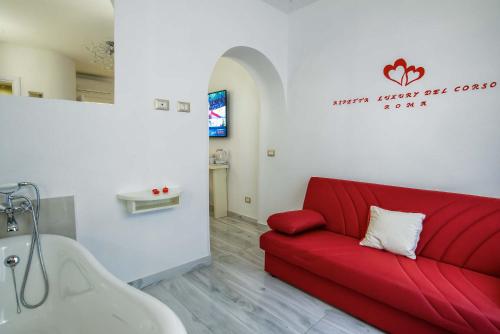 a living room with a red couch and a sink at Ripetta Luxury Del Corso in Rome