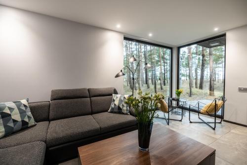 a living room with a couch and a table at Jūras Krasti Romantika in Jūrmalciems