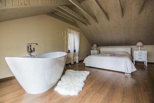 a white bath tub in a room with a bed at Jūras Krasti Romantika in Jūrmalciems