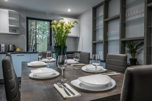 a dining room table with plates and wine glasses at Jūras Krasti Romantika in Jūrmalciems