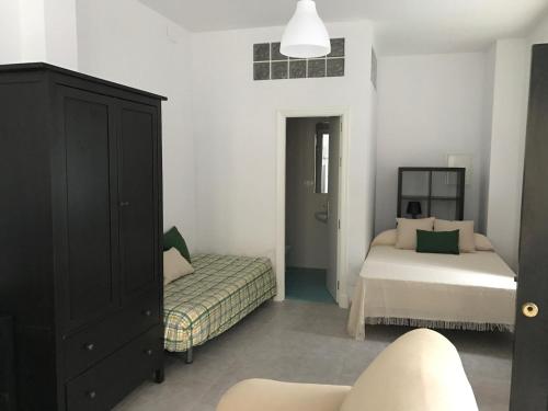 - une chambre avec 2 lits et une commode dans l'établissement Apartamento/Loft en Zona Céntrica I WIFI, à Jerez de la Frontera