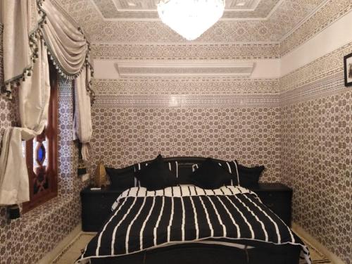 馬拉喀什的住宿－Riad Oum Ellkhir，一间卧室配有一张床和一个吊灯